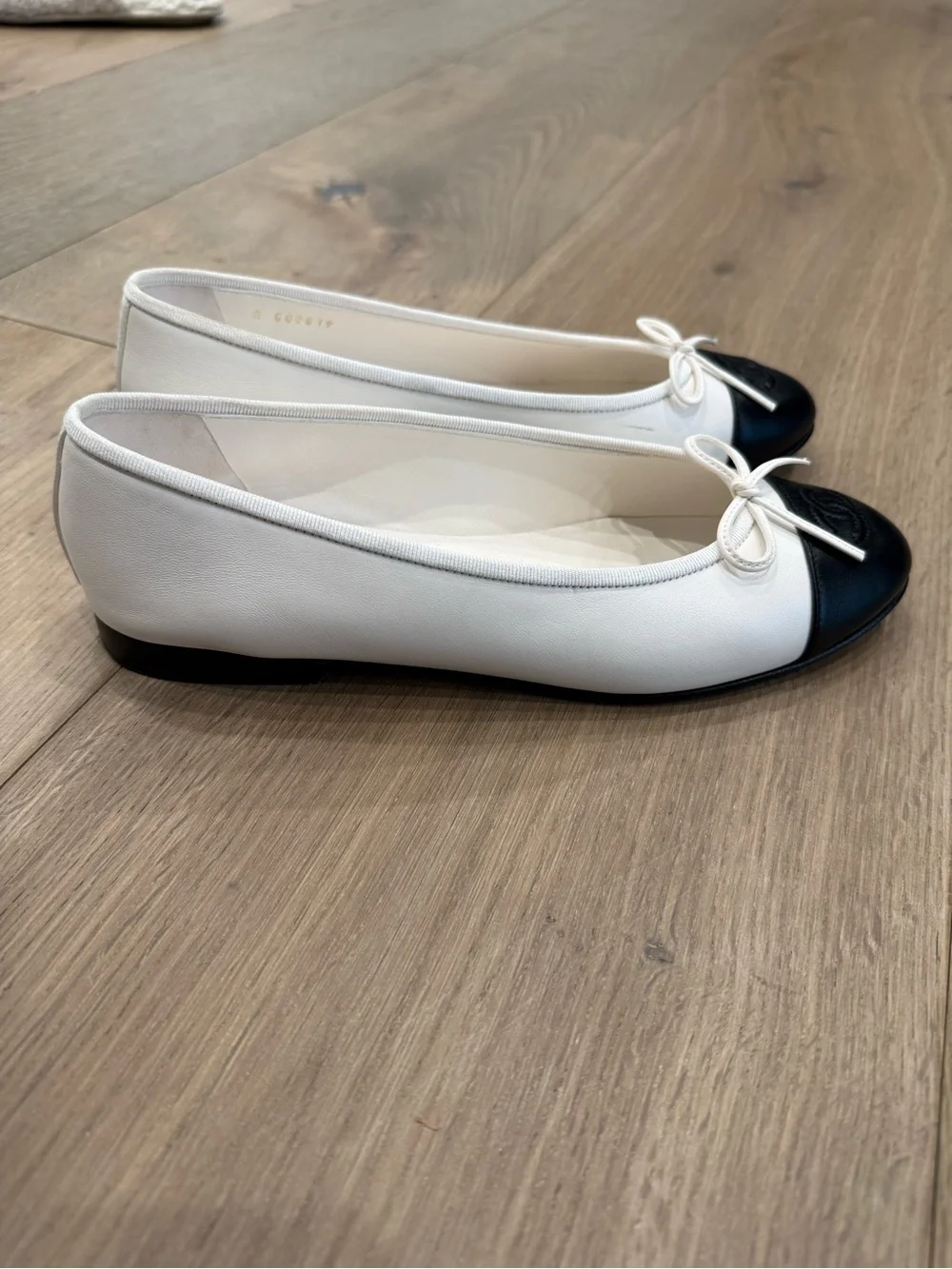 CHANEL Two-Tone Leather Cap-Toe Ballet Flats in White and Black